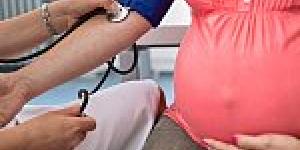 checking blood pressure of pregnant woman