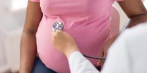 Pregnant woman getting checked by doctor with stethoscope